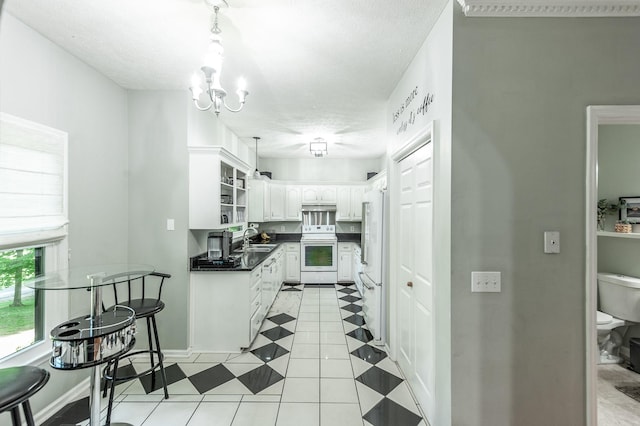 1505 Newmans Trl, Hendersonville, TN 37075 - kitchen with dark countertops, white appliances, white cabinetry, a sink, and hanging light fixtures