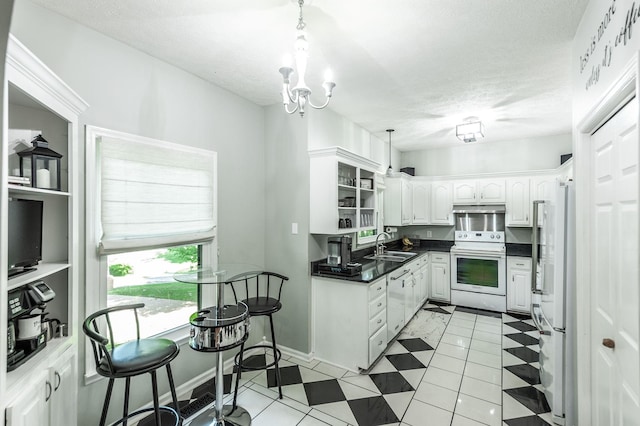 1505 Newmans Trl, Hendersonville, TN 37075 - kitchen featuring dark countertops, white appliances, under cabinet range hood, white cabinets, and a sink