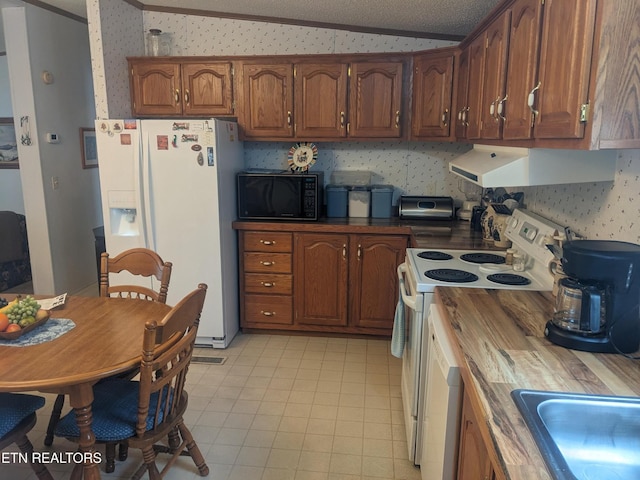 805 N Front St, Rockwood, TN 37854 - kitchen featuring white appliances, lofted ceiling, under cabinet range hood, wallpapered walls, and brown cabinetry