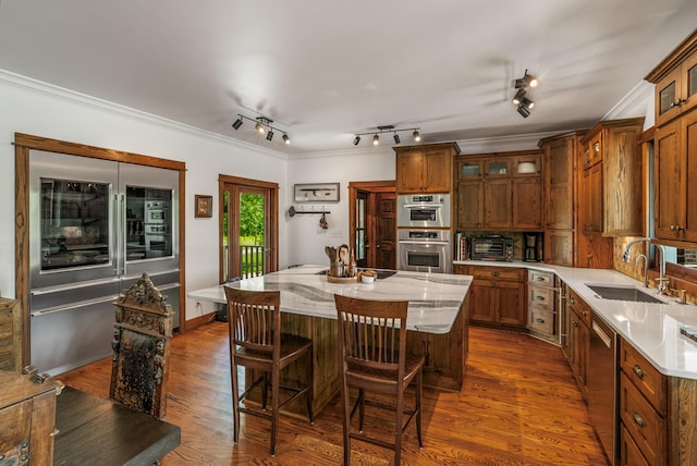 5959 River Trce, Nashville, TN 37218 - kitchen with glass insert cabinets, an island with sink, a kitchen bar, a sink, and appliances with stainless steel finishes