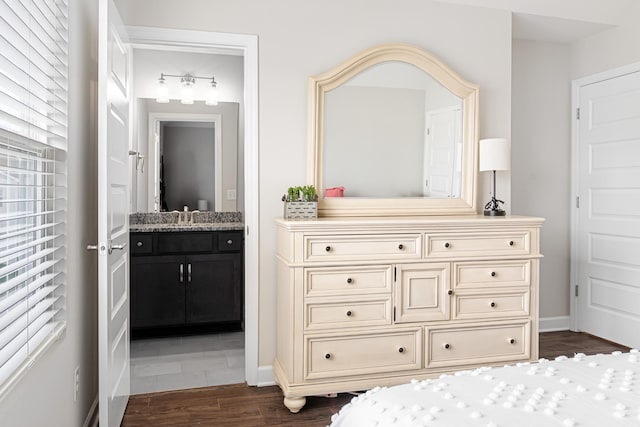 bathroom with baseboards, wood finished floors, and vanity
