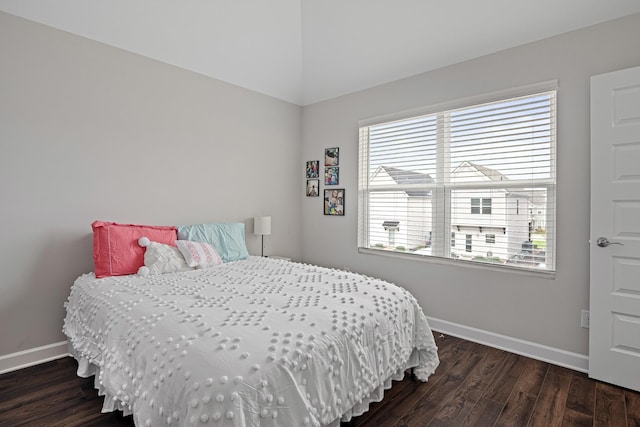 bedroom featuring baseboards, multiple windows, wood finished floors, and lofted ceiling