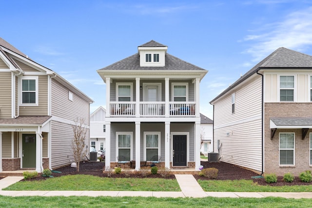 view of front facade featuring central air condition unit, a shingled roof, a porch, and a balcony