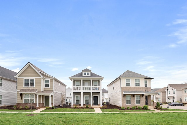 craftsman house featuring brick siding, a front lawn, and a balcony