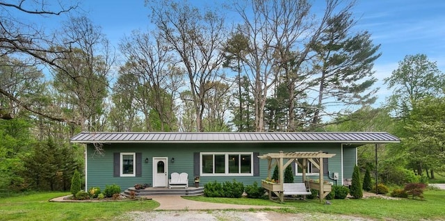 back of property featuring a yard and metal roof