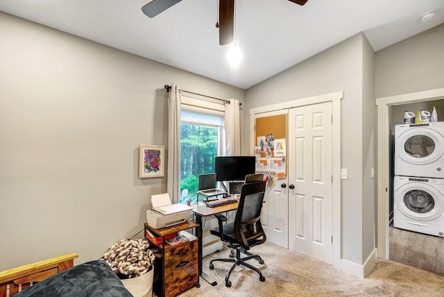 office with carpet floors, baseboards, a ceiling fan, and stacked washer / dryer