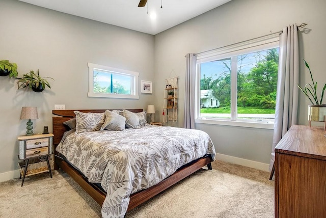 bedroom featuring baseboards, light colored carpet, and ceiling fan