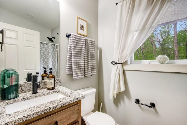 full bathroom with toilet, a shower with shower curtain, and vanity