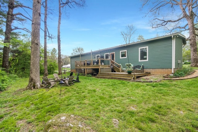 back of house featuring a lawn and a wooden deck