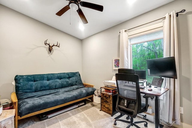 carpeted office space with a ceiling fan
