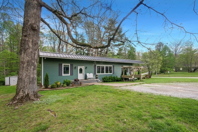 ranch-style house with an outdoor structure, a front lawn, a shed, and metal roof