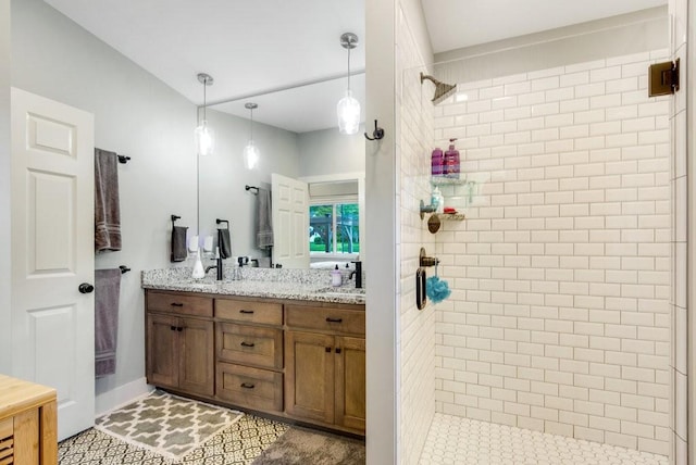 bathroom with double vanity, a stall shower, and a sink