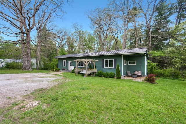back of property with a lawn, a deck, and metal roof