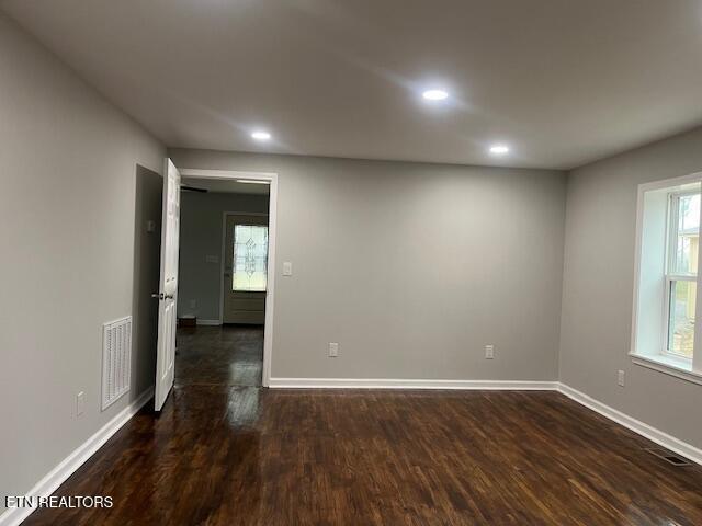 empty room featuring recessed lighting, visible vents, baseboards, and dark wood-style floors