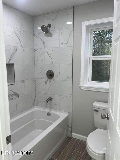 full bath with toilet, baseboards, bathtub / shower combination, and wood finish floors