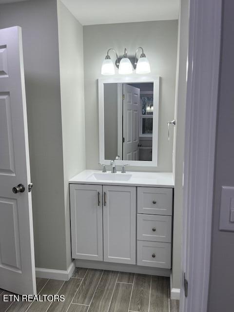 bathroom featuring vanity, wood tiled floor, and baseboards