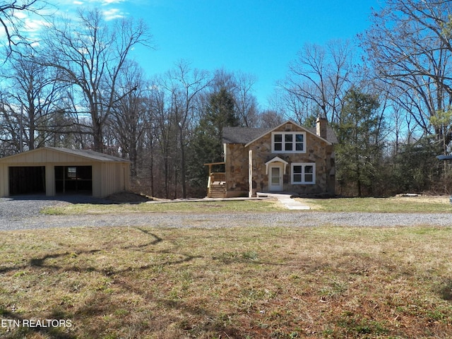 view of front facade featuring a chimney, a front yard, an outdoor structure, a pole building, and stone siding