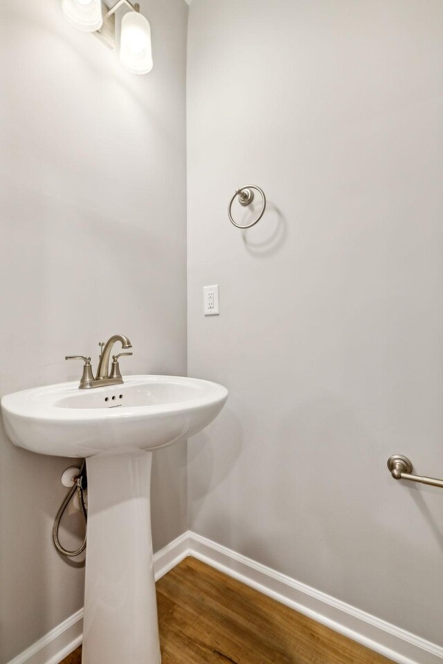 bathroom with baseboards and wood finished floors