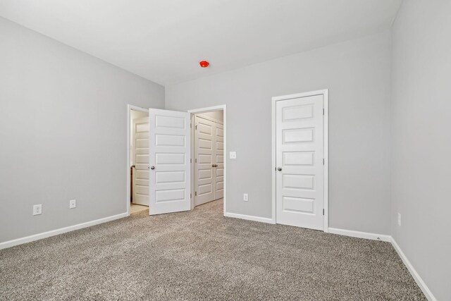 unfurnished bedroom with baseboards and carpet flooring