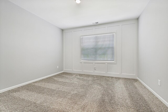 empty room with visible vents, carpet, and baseboards