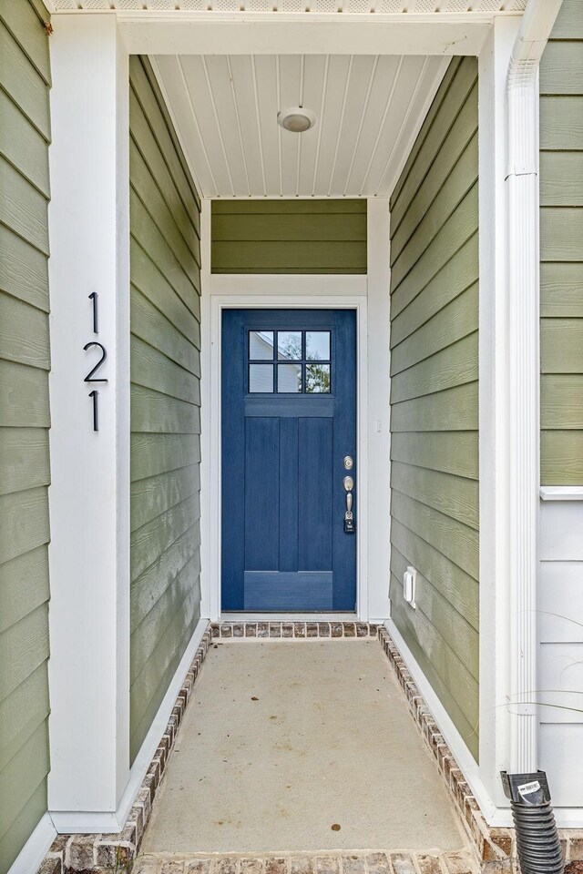 view of exterior entry featuring covered porch