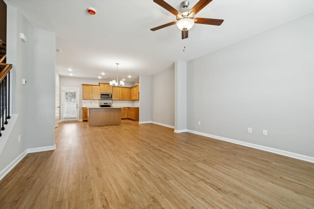 unfurnished living room featuring baseboards, stairway, recessed lighting, light wood finished floors, and ceiling fan with notable chandelier