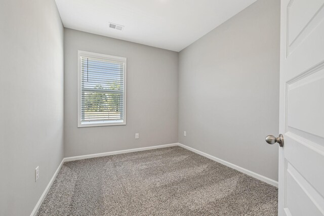 carpeted empty room with visible vents and baseboards