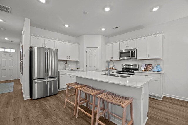 kitchen with visible vents, a sink, dark wood-style floors, and stainless steel appliances