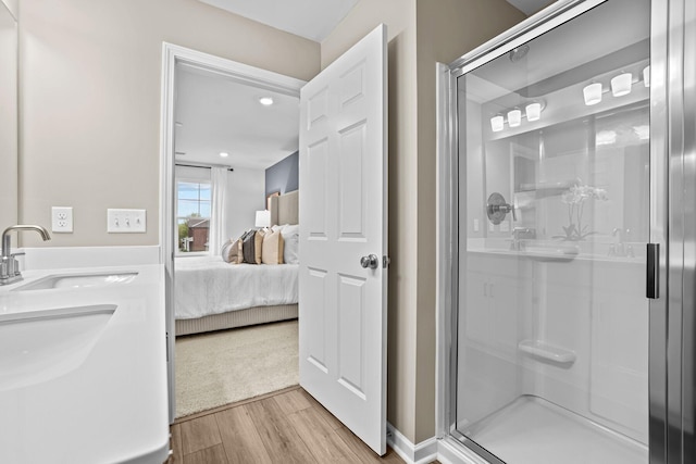 ensuite bathroom with a shower stall, wood finished floors, and ensuite bath