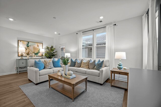 living area featuring baseboards, recessed lighting, wood finished floors, and visible vents