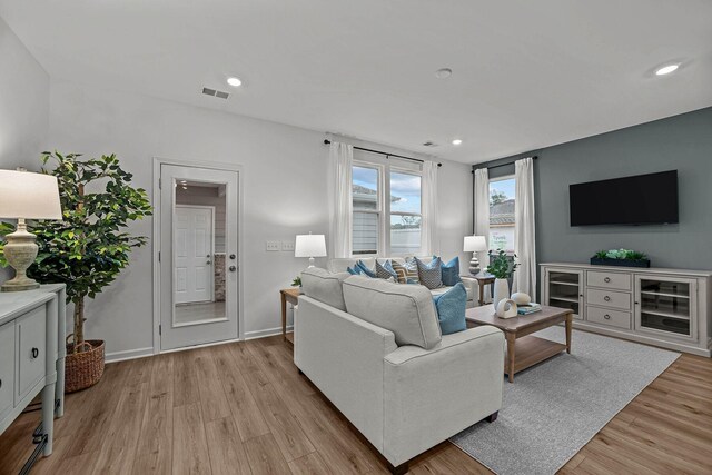 living area featuring recessed lighting, baseboards, visible vents, and light wood-style floors