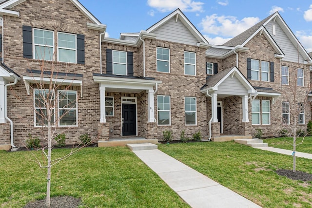 view of front of house featuring brick siding and a front yard