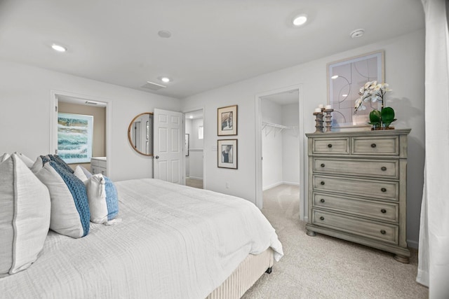 bedroom with baseboards, light carpet, recessed lighting, and a spacious closet