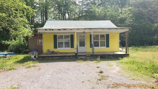bungalow featuring concrete block siding and a porch