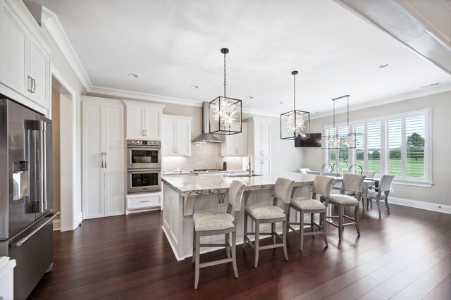 kitchen with stainless steel appliances, a notable chandelier, a sink, and dark wood-type flooring