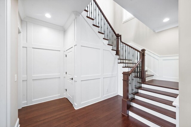 stairway featuring a wainscoted wall, recessed lighting, wood finished floors, and a decorative wall