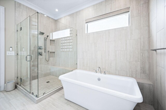 full bath with crown molding, a soaking tub, and a shower stall