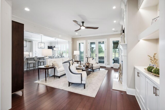 living room featuring dark wood-style flooring, a ceiling fan, recessed lighting, and ornamental molding