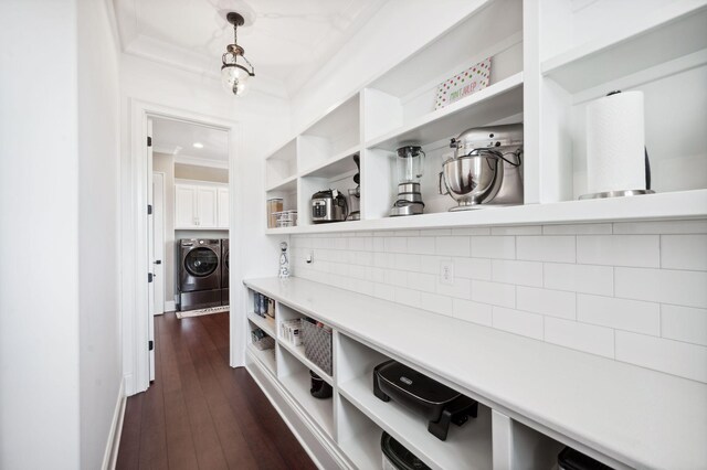 mudroom featuring washing machine and dryer, baseboards, ornamental molding, and dark wood-type flooring