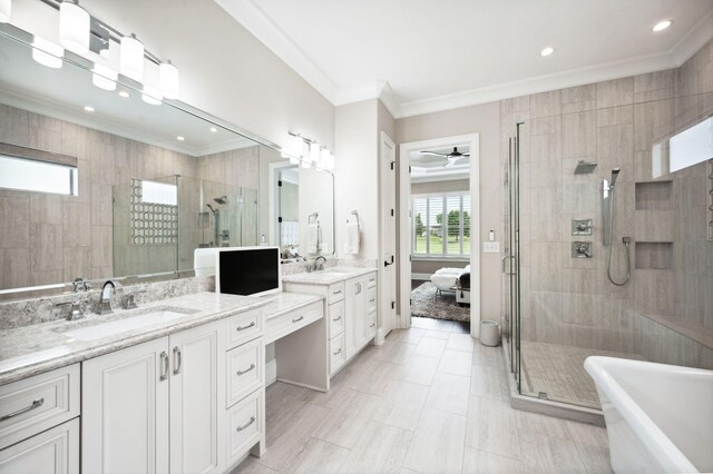 bathroom featuring crown molding, two vanities, a sink, and a stall shower