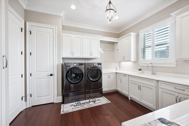 laundry room featuring independent washer and dryer, cabinet space, a sink, dark wood-style floors, and an inviting chandelier