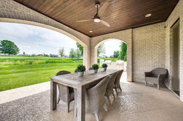view of patio with an outdoor kitchen, ceiling fan, and outdoor dining area