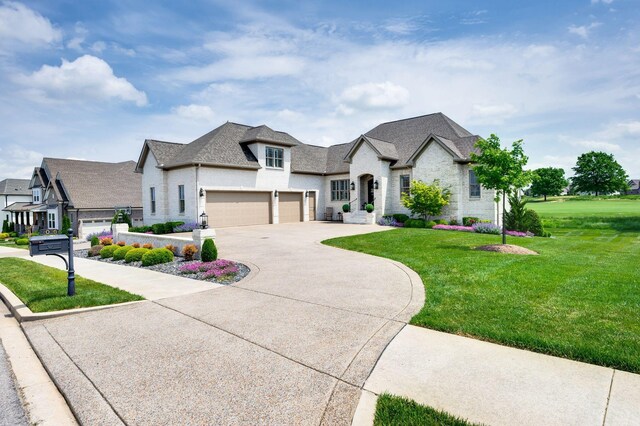french country style house with an attached garage, a front lawn, and concrete driveway