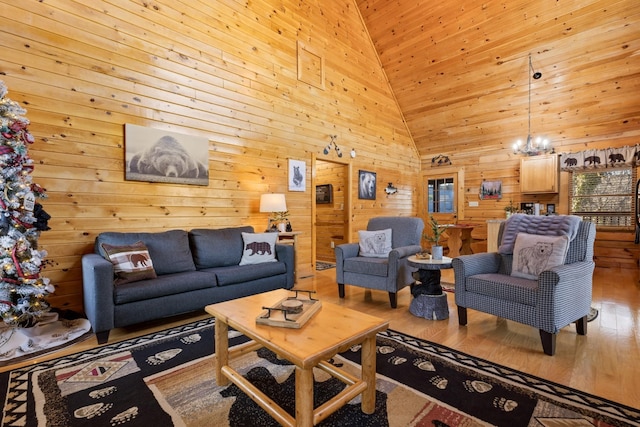 living area with high vaulted ceiling, wood walls, wood finished floors, and a notable chandelier