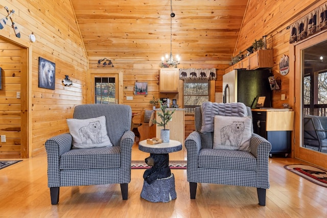 sitting room featuring light wood-style floors, wood walls, wood ceiling, and high vaulted ceiling