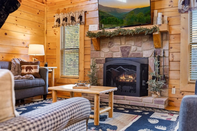 living room with wood walls and a stone fireplace