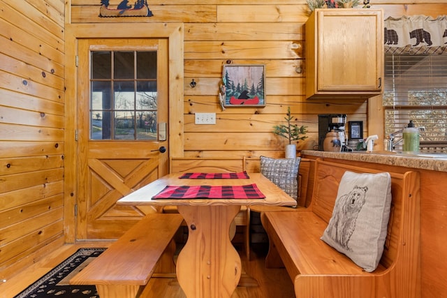 dining room featuring wooden walls and breakfast area