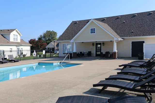 pool with a patio and fence