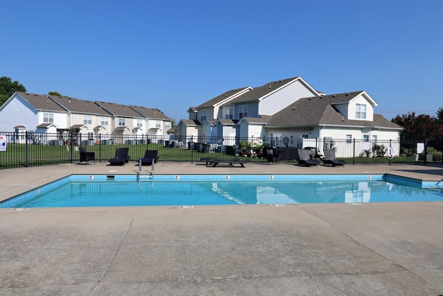 pool featuring a patio area, fence, and a residential view