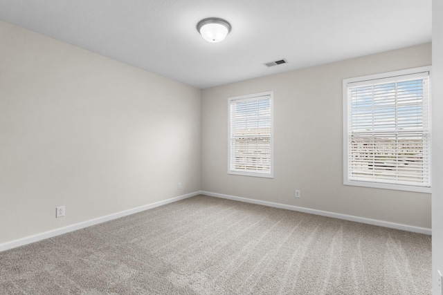carpeted spare room with baseboards and visible vents